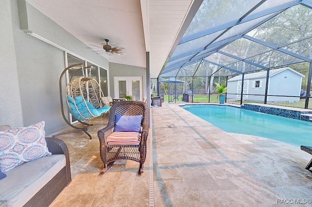 outdoor pool featuring glass enclosure, ceiling fan, french doors, and a patio