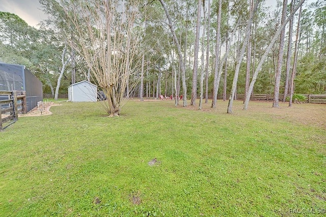 view of yard with an outbuilding, fence, and a shed