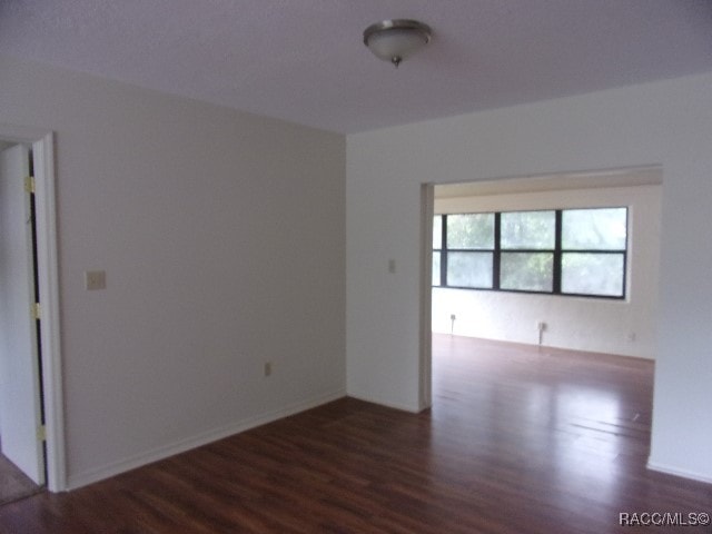 unfurnished room featuring dark hardwood / wood-style flooring