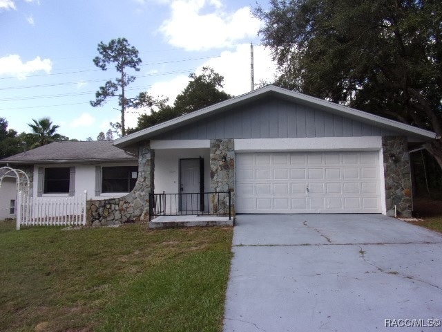 ranch-style house with a front yard and a garage