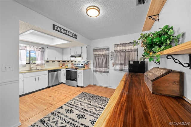 kitchen featuring sink, white cabinets, stainless steel appliances, and a textured ceiling