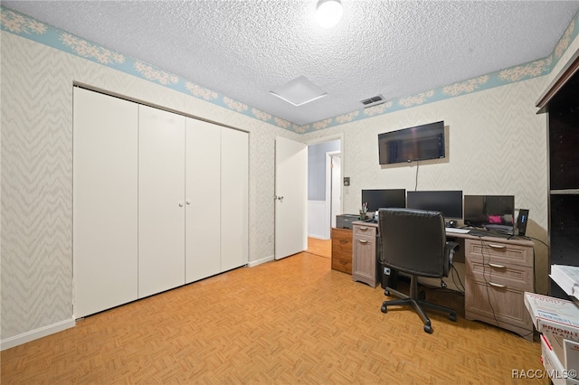 home office with light parquet flooring and a textured ceiling