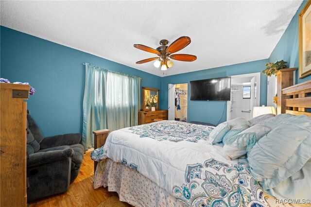 bedroom with a textured ceiling, light hardwood / wood-style floors, and ceiling fan