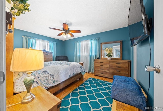 bedroom featuring wood-type flooring, a textured ceiling, and ceiling fan