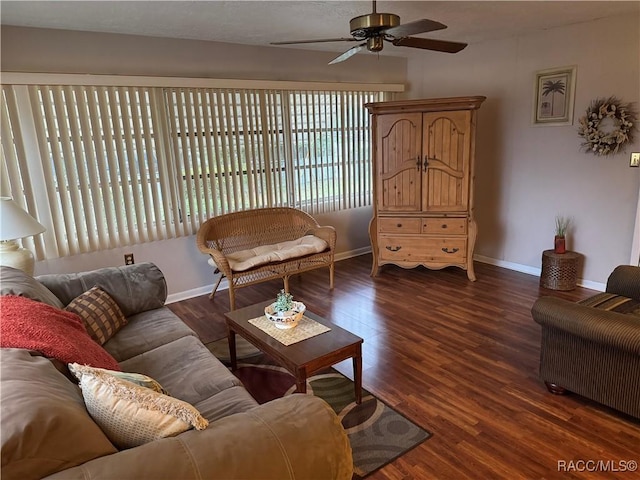 living room featuring ceiling fan, baseboards, and dark wood-style flooring