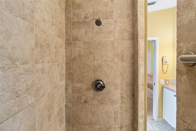 details featuring vanity and a tile shower