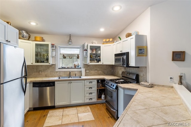 kitchen with white cabinets, appliances with stainless steel finishes, and light hardwood / wood-style floors