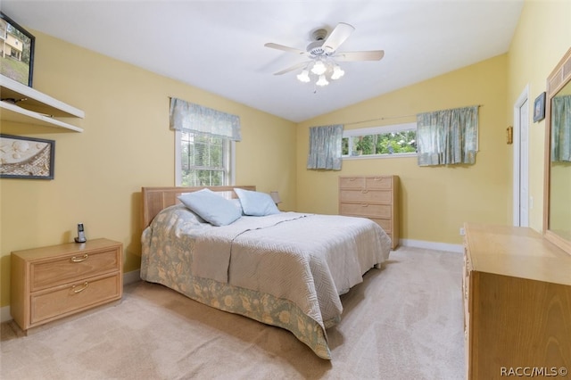 carpeted bedroom featuring vaulted ceiling, multiple windows, and ceiling fan