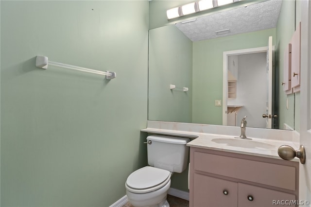 bathroom featuring vanity, a textured ceiling, and toilet