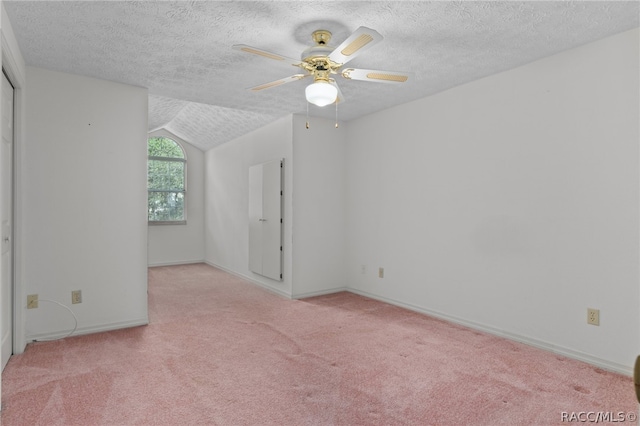 interior space featuring a textured ceiling, light carpet, and vaulted ceiling