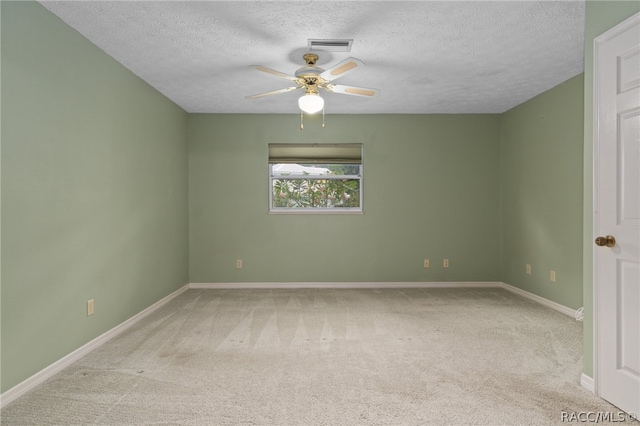 carpeted spare room featuring ceiling fan and a textured ceiling