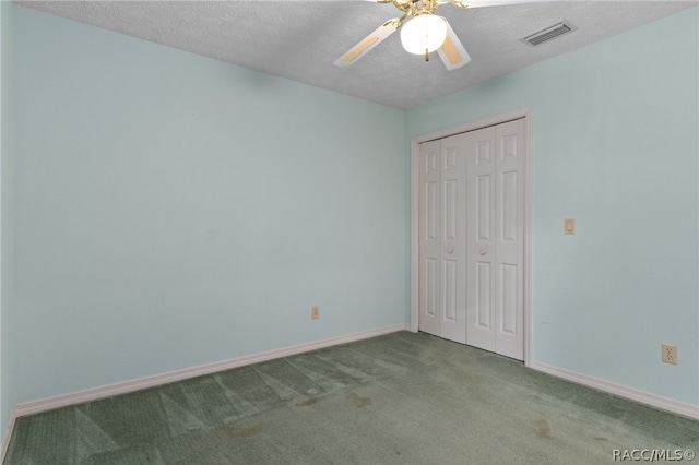 unfurnished bedroom featuring carpet, ceiling fan, a textured ceiling, and a closet