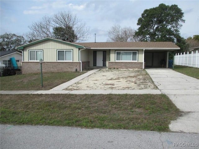 single story home with an attached carport, concrete driveway, brick siding, and a front lawn