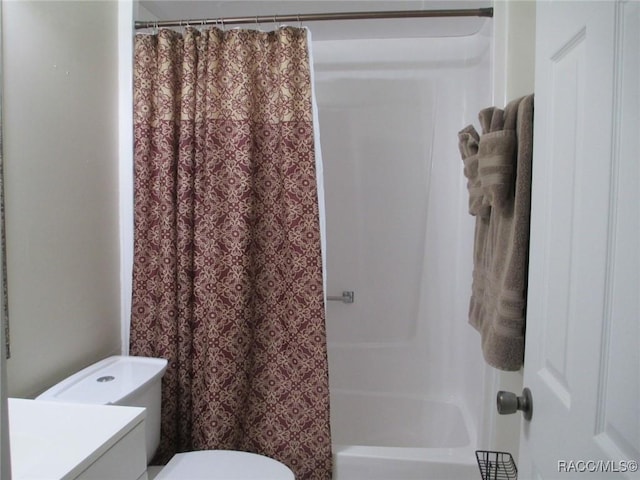 bathroom featuring vanity, toilet, and shower / bath combo with shower curtain