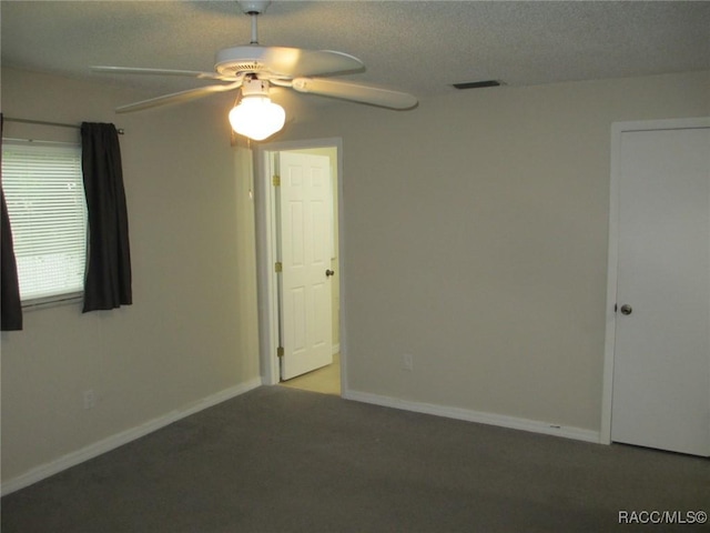 unfurnished room featuring a textured ceiling, baseboards, a ceiling fan, and light colored carpet