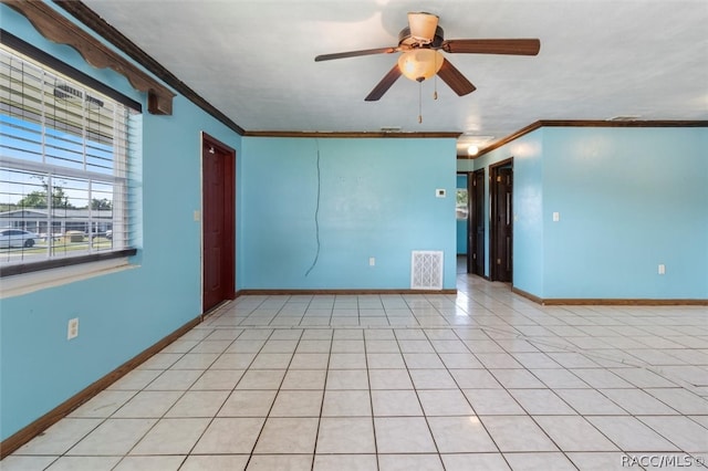 tiled spare room featuring ceiling fan and ornamental molding