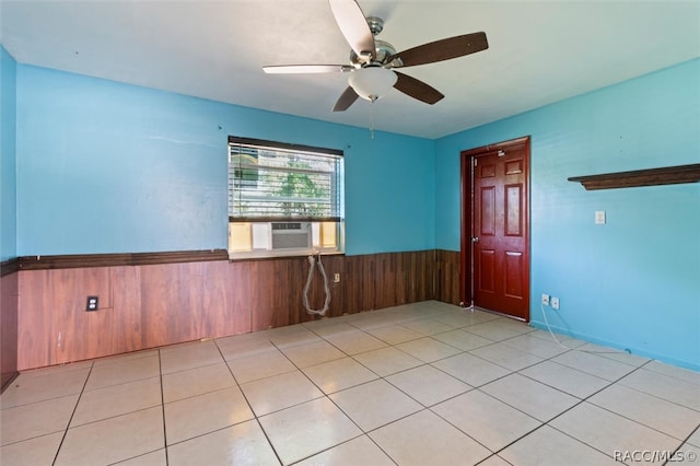 tiled spare room with ceiling fan, cooling unit, and wood walls