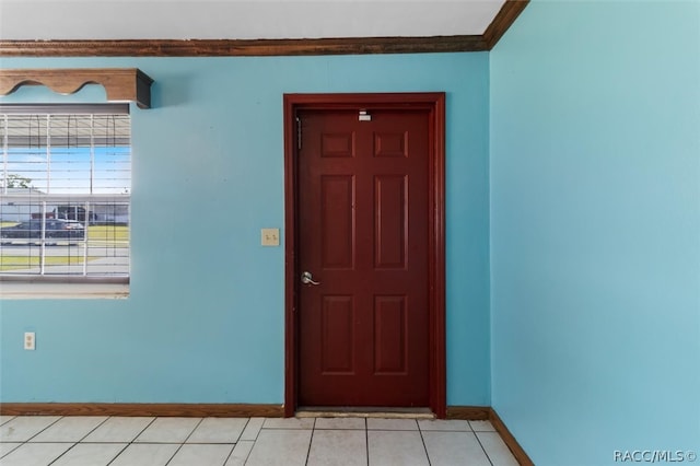 tiled foyer entrance featuring crown molding