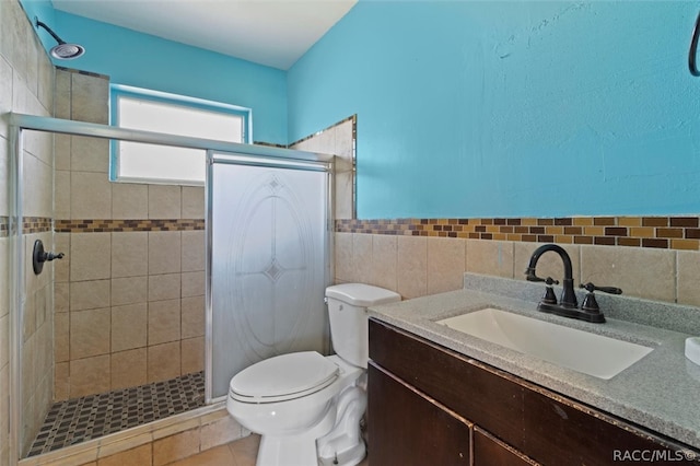 bathroom with walk in shower, tile patterned flooring, toilet, vanity, and tile walls