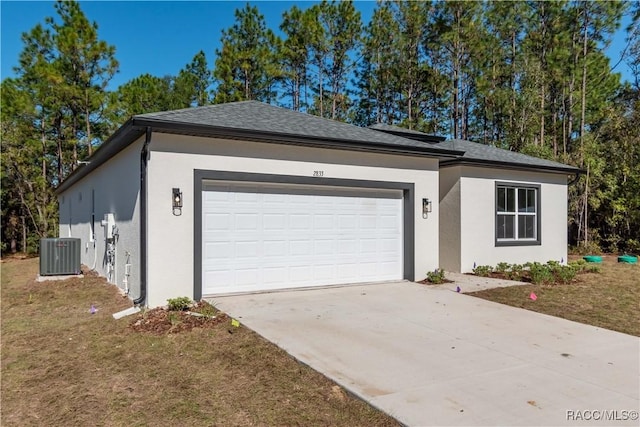 garage featuring central air condition unit and a yard