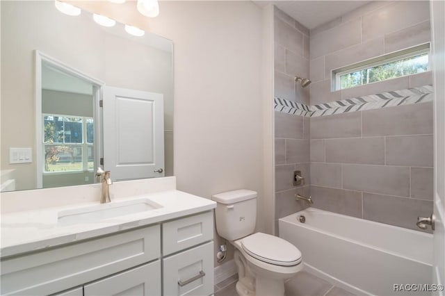 full bathroom featuring tiled shower / bath, vanity, toilet, and a wealth of natural light