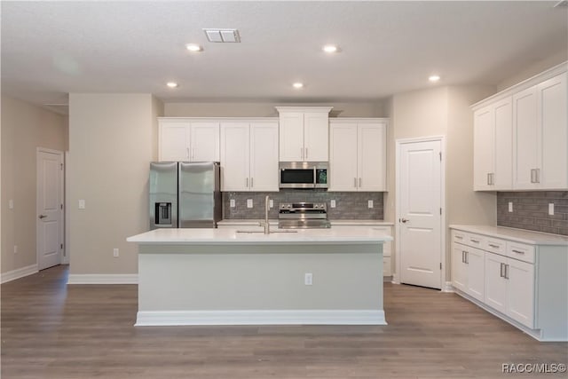 kitchen featuring a kitchen island with sink, sink, appliances with stainless steel finishes, light hardwood / wood-style floors, and white cabinetry