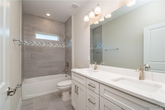 full bathroom with tile patterned floors, vanity, tiled shower / bath combo, and toilet