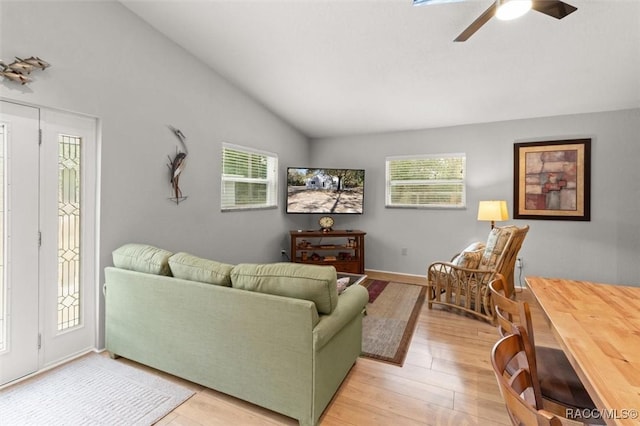 living room with ceiling fan, lofted ceiling, and light hardwood / wood-style floors