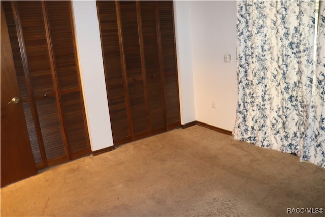 unfurnished bedroom with carpet floors and two closets