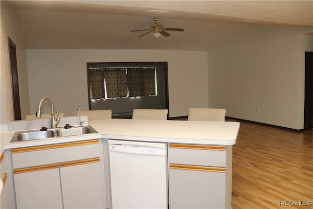 kitchen with kitchen peninsula, light wood-type flooring, white dishwasher, and white cabinetry