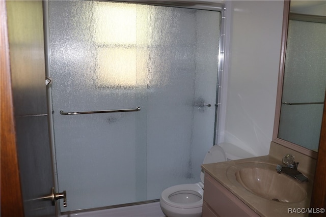 bathroom featuring toilet, vanity, and walk in shower