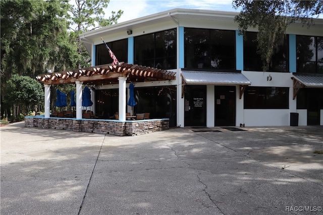 view of front facade featuring a pergola and a patio area