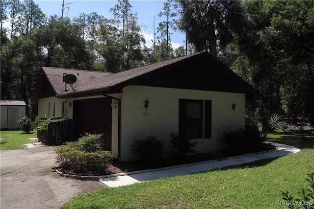 view of home's exterior featuring a lawn and a garage