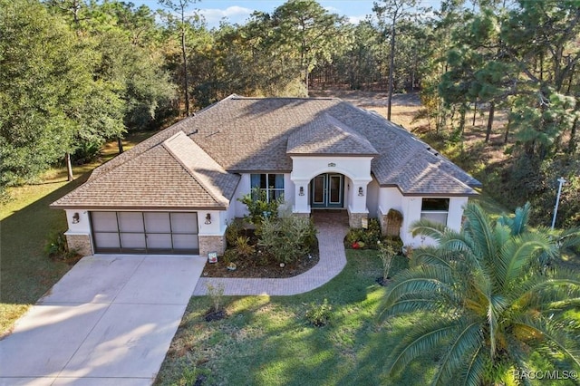 view of front of house featuring a front lawn, a garage, and french doors