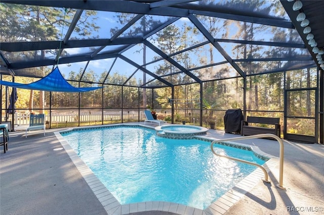 view of pool featuring glass enclosure, an in ground hot tub, and a patio