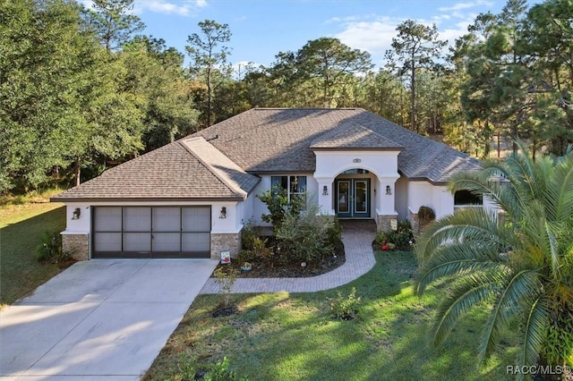 view of front facade featuring a garage, a front yard, and french doors