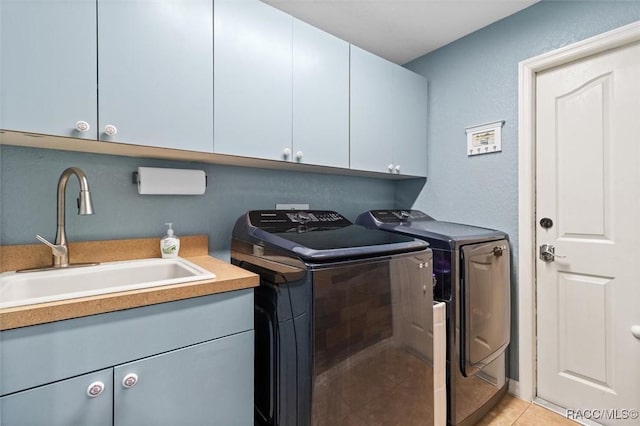 washroom featuring separate washer and dryer, sink, light tile patterned floors, and cabinets