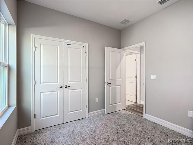 unfurnished bedroom featuring carpet floors and a closet