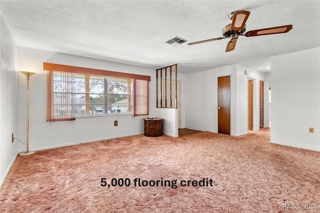 spare room with ceiling fan, a textured ceiling, and carpet