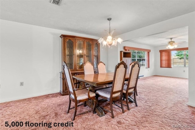 carpeted dining space featuring an inviting chandelier