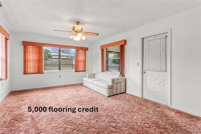 unfurnished living room featuring ceiling fan, plenty of natural light, and carpet