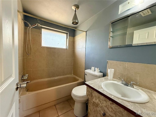 full bathroom with tile patterned floors, toilet, tiled shower / bath combo, and vanity