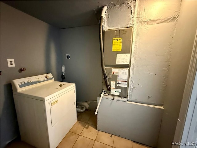 washroom with washer / dryer, heating unit, and light tile patterned floors