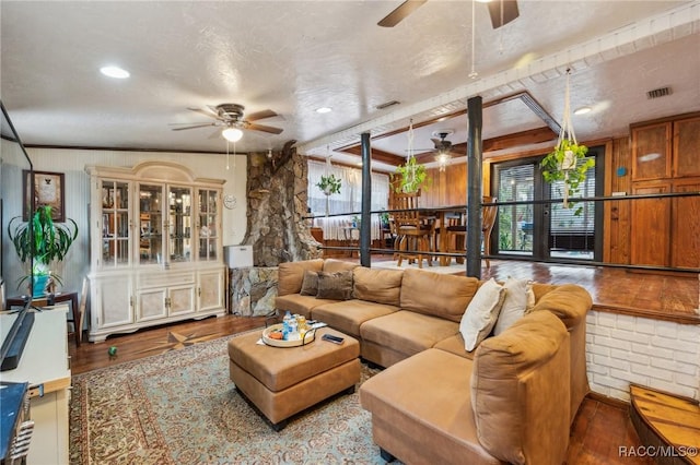 living room featuring wood-type flooring, plenty of natural light, and ceiling fan