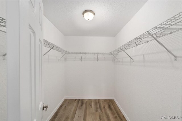 unfurnished bedroom with baseboards, a closet, visible vents, and light wood-style floors