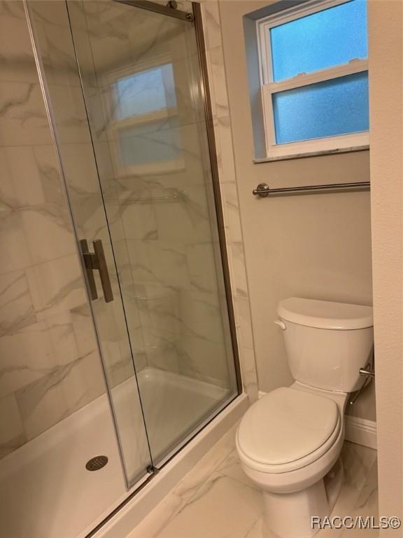 full bath featuring  shower combination, marble finish floor, vanity, and toilet