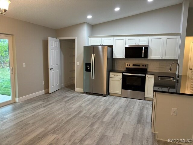 empty room with ceiling fan, a textured ceiling, baseboards, and wood finished floors