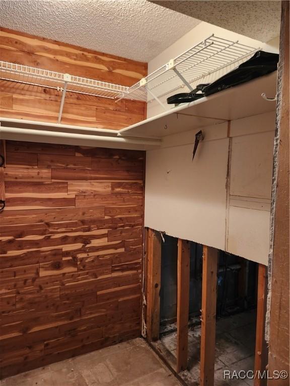 basement with wooden walls and a textured ceiling