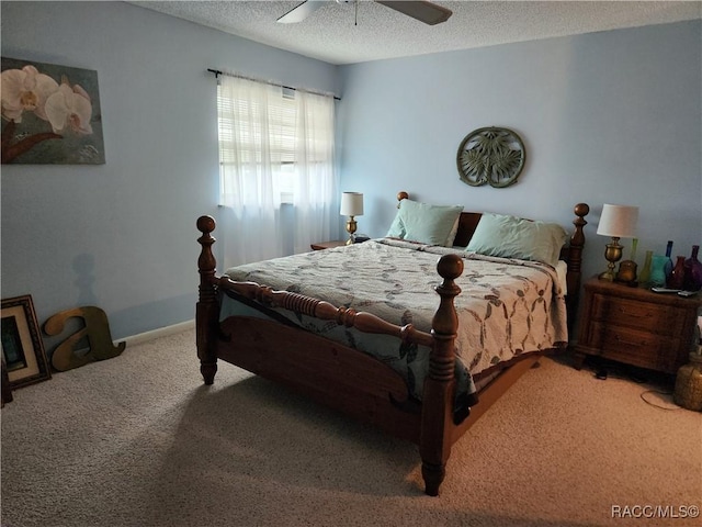 carpeted bedroom featuring ceiling fan and a textured ceiling