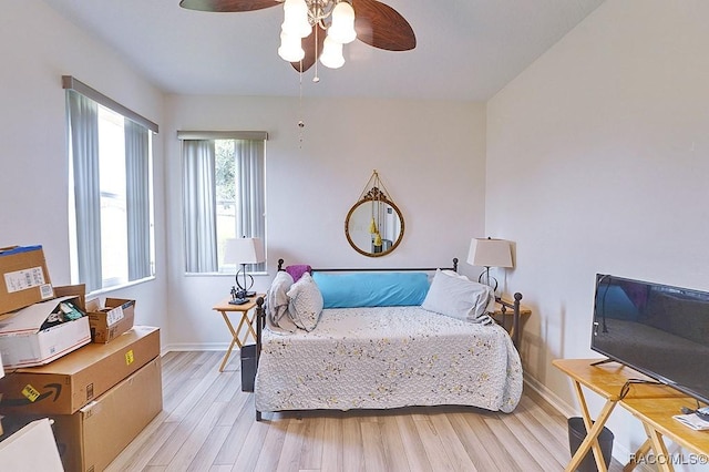 bedroom with baseboards, ceiling fan, and light wood-style floors